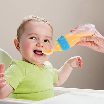 Happy baby eating from a smart feeding spoon, designed for easy grip and gentle on gums.